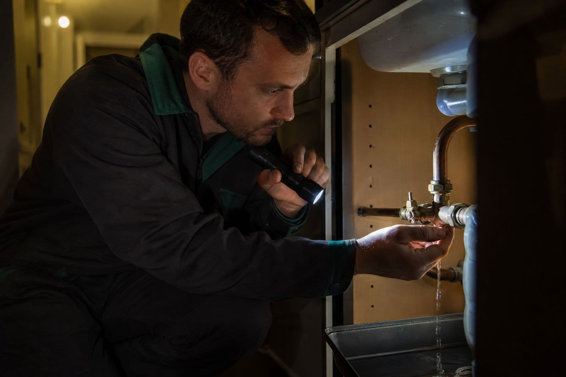 GEM engineer tracing a live leak by torchlight during a night emergency callout